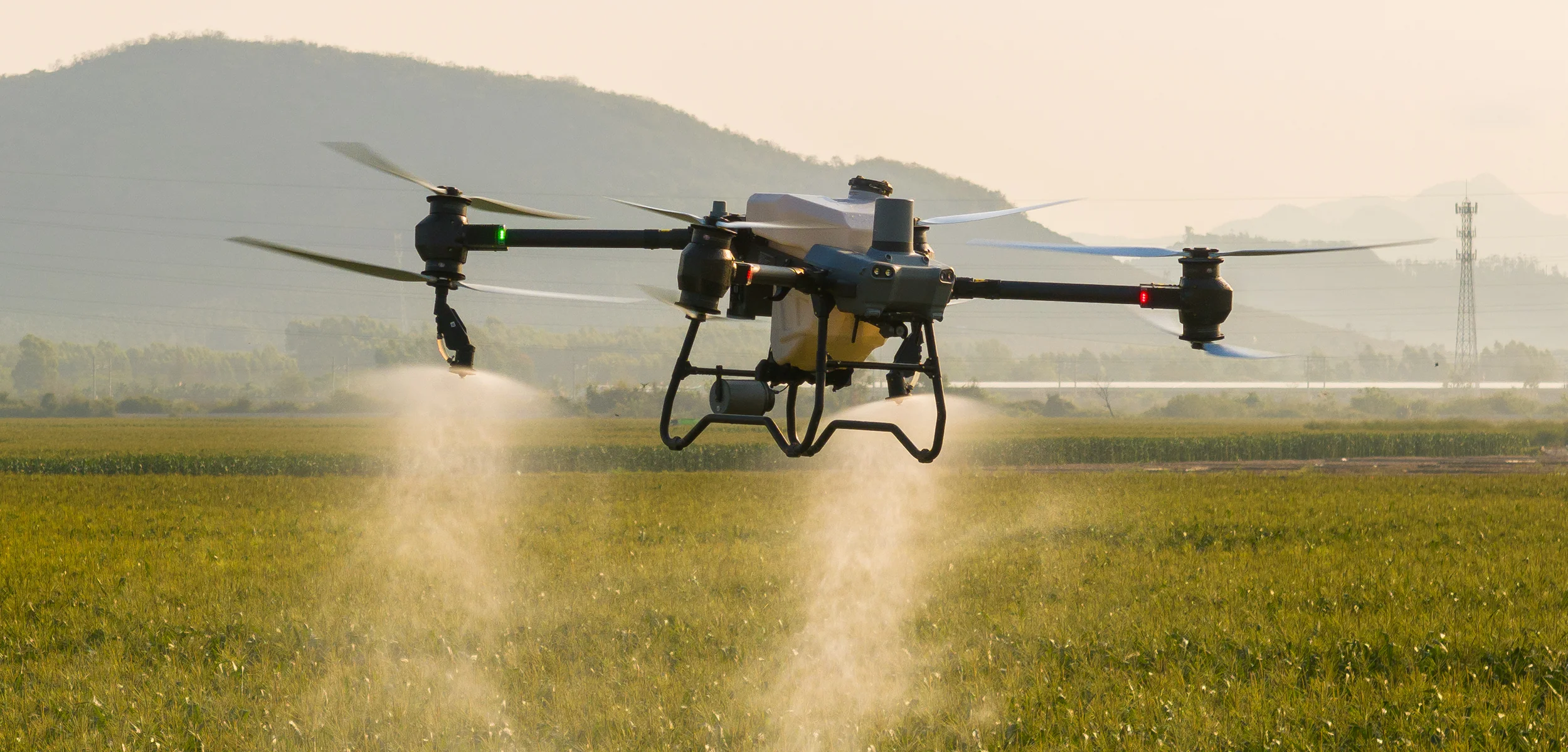Dron aplicador pulverizando un lote al atardecer